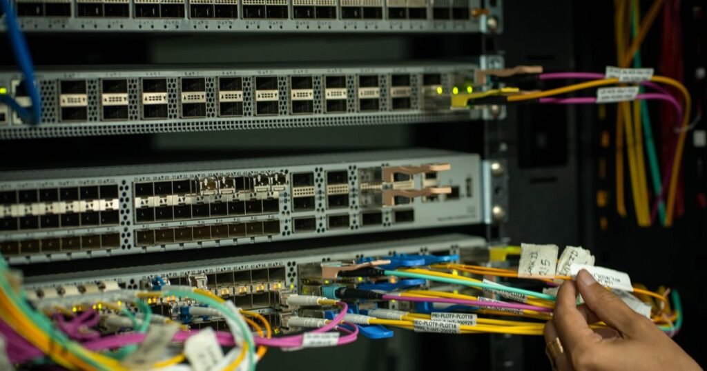 Technicien raccordant des câbles fibre en baie — aide au raccordement fibre et dispositif DGE