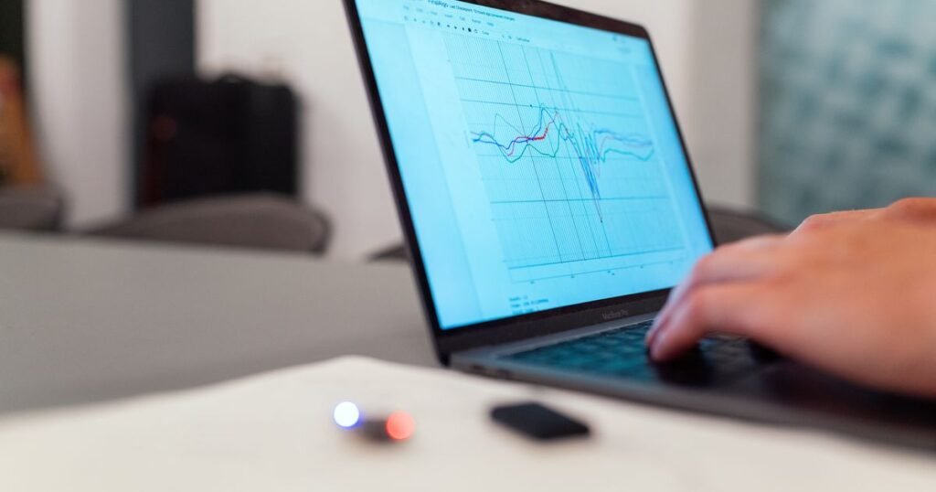 Personne analysant des données sur un ordinateur portable, illustrant la consultation du fichier de trajectoire pour trouver la date de fermeture du réseau cuivre