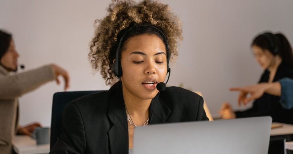 Personne avec un casque en communication devant un ordinateur — la téléphonie d'entreprise bascule vers le cloud